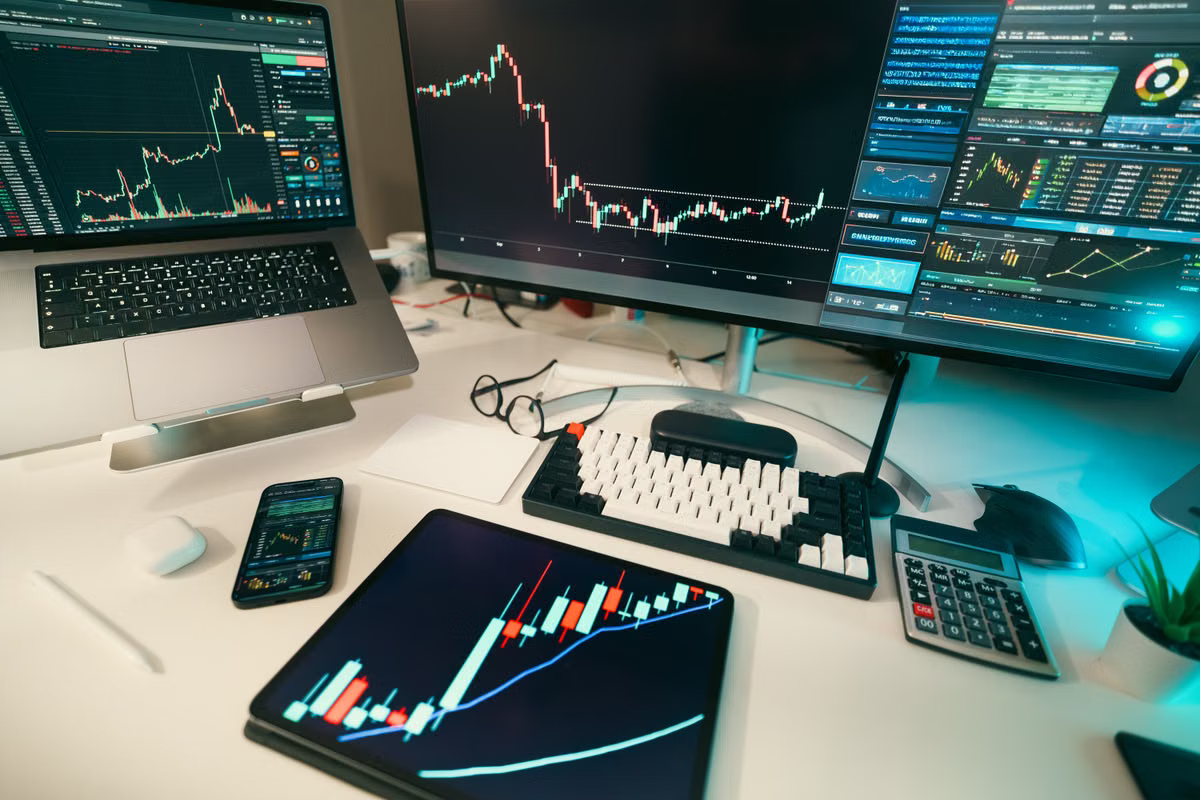 A trading desk with multiple screens showing financial charts